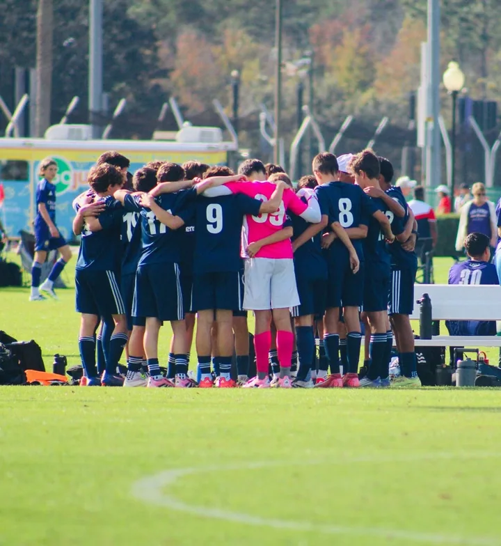Players with arms around one another in a team huddle