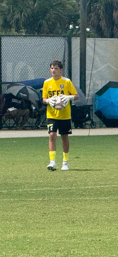 Gavin holding a ball in a yellow SFFA goalkeeper shirt